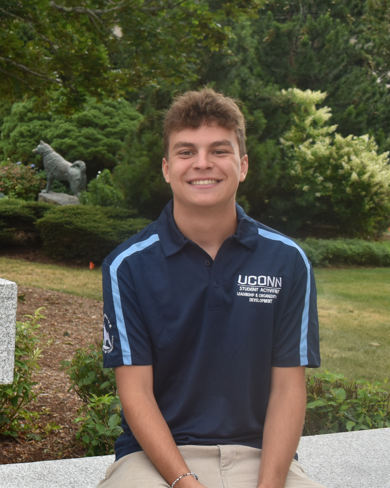 Luke posing in front of the Husky statue