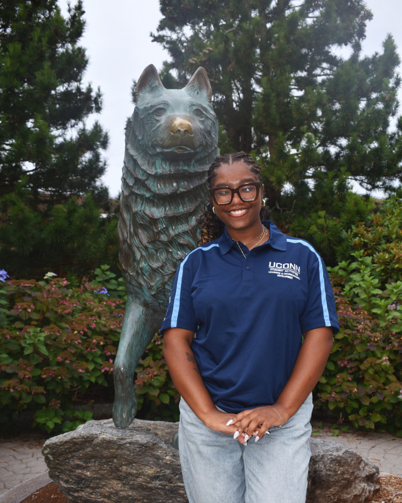 Olivia posing with the Husky Dog statue
