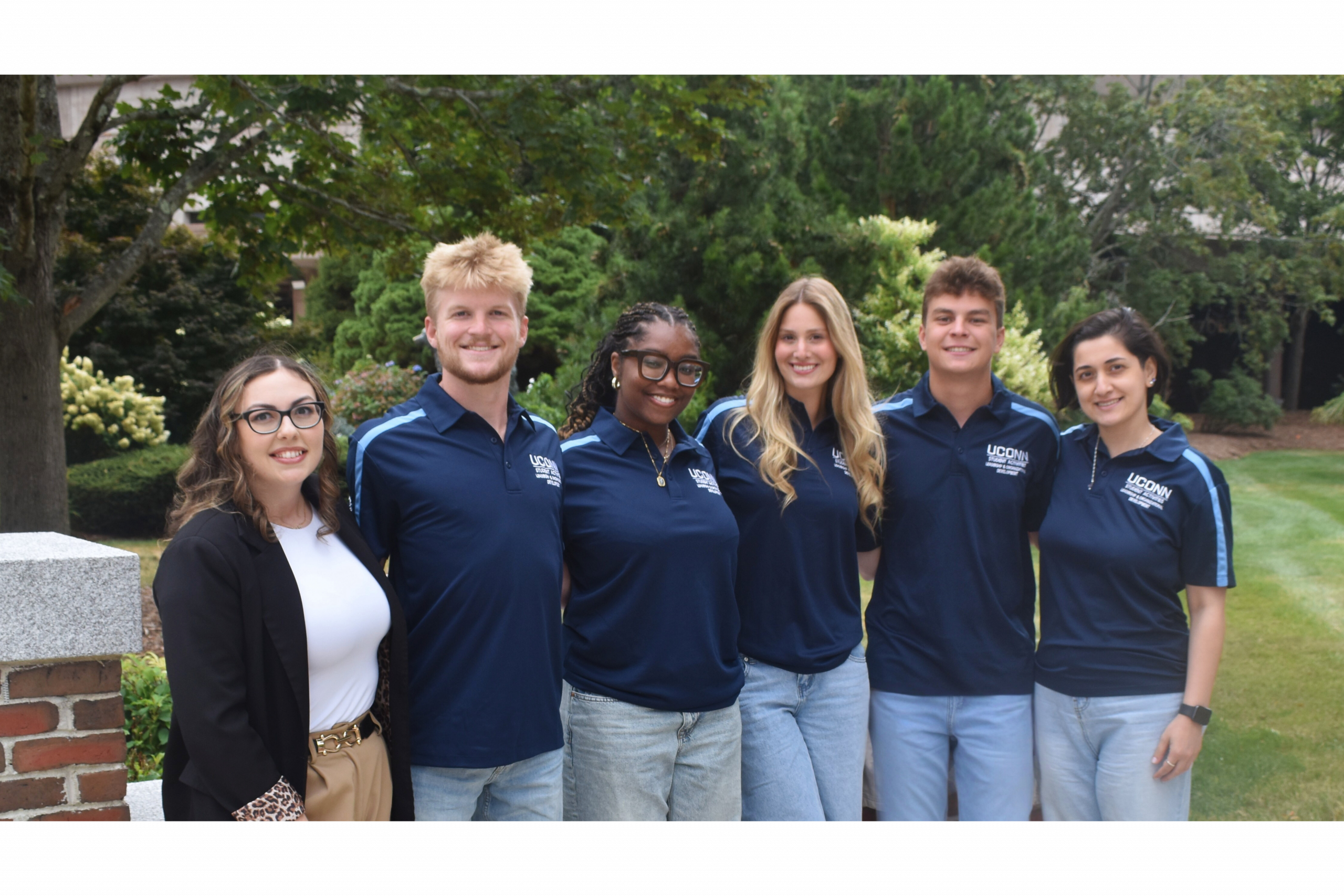 The SOLID Office team pose in front of the Jonathan The Husky statue for a staff photo